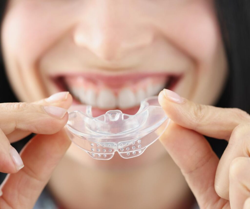 A patient holding an oral appliance used in sleep apnea treatment in Anchorage, AK